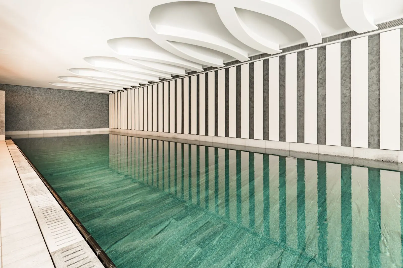 Hallenbad im Chenot Palace Weggis mit grünen Platten und Streifenwand